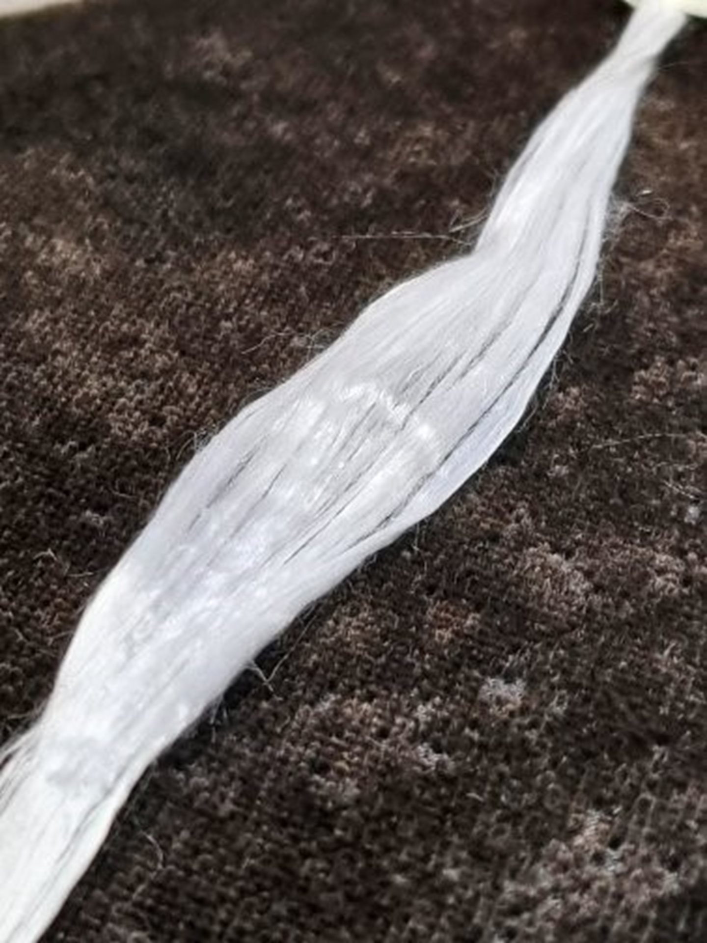 Fiber av återvunnen textil framställd i labbskala med hjälp ev projektparten TreeToTextiles process.